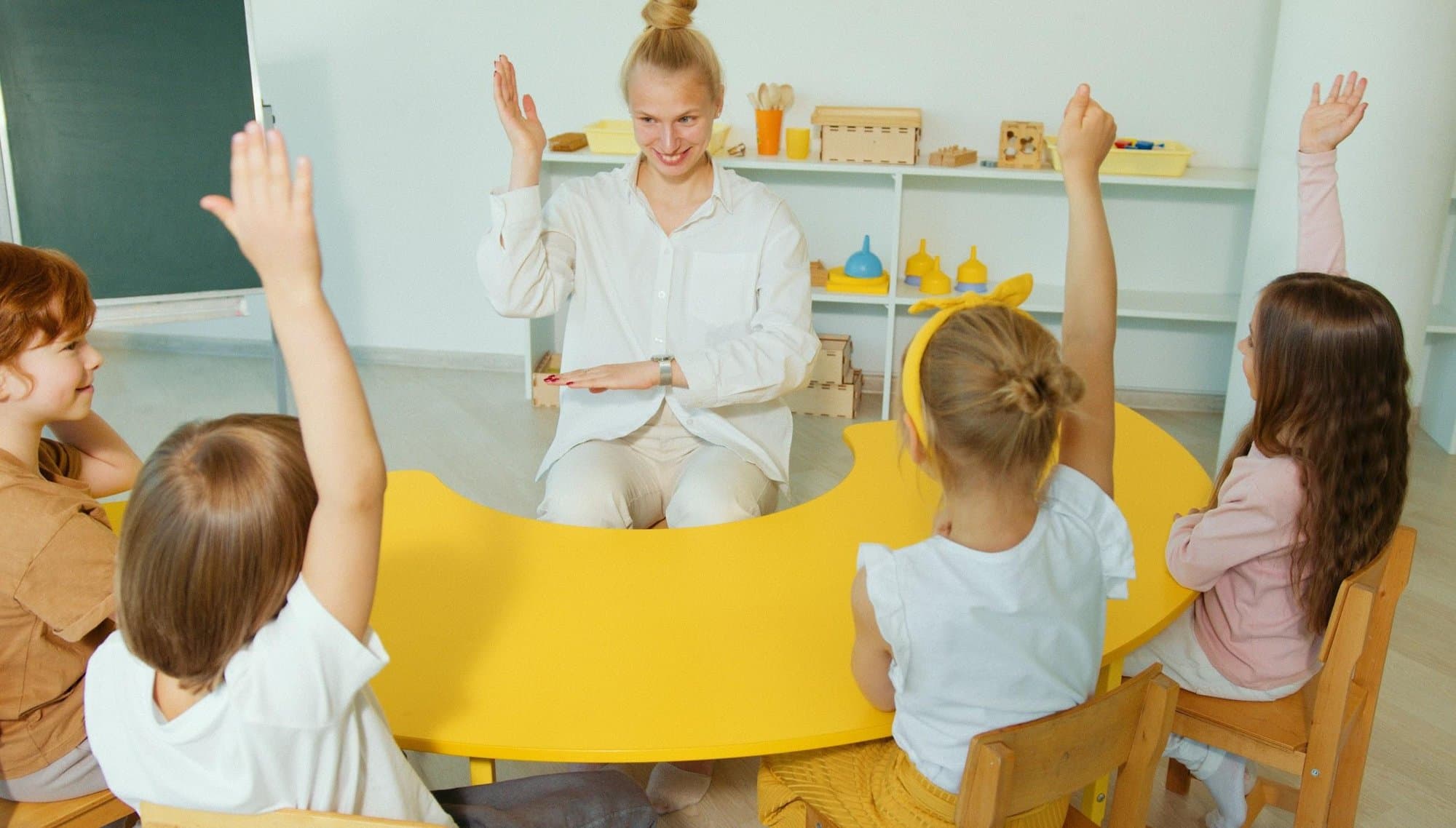 A teacher and children engaged in a classroom activity together